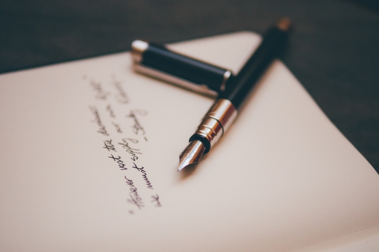 A pen laying on a piece of paper with writing on it.